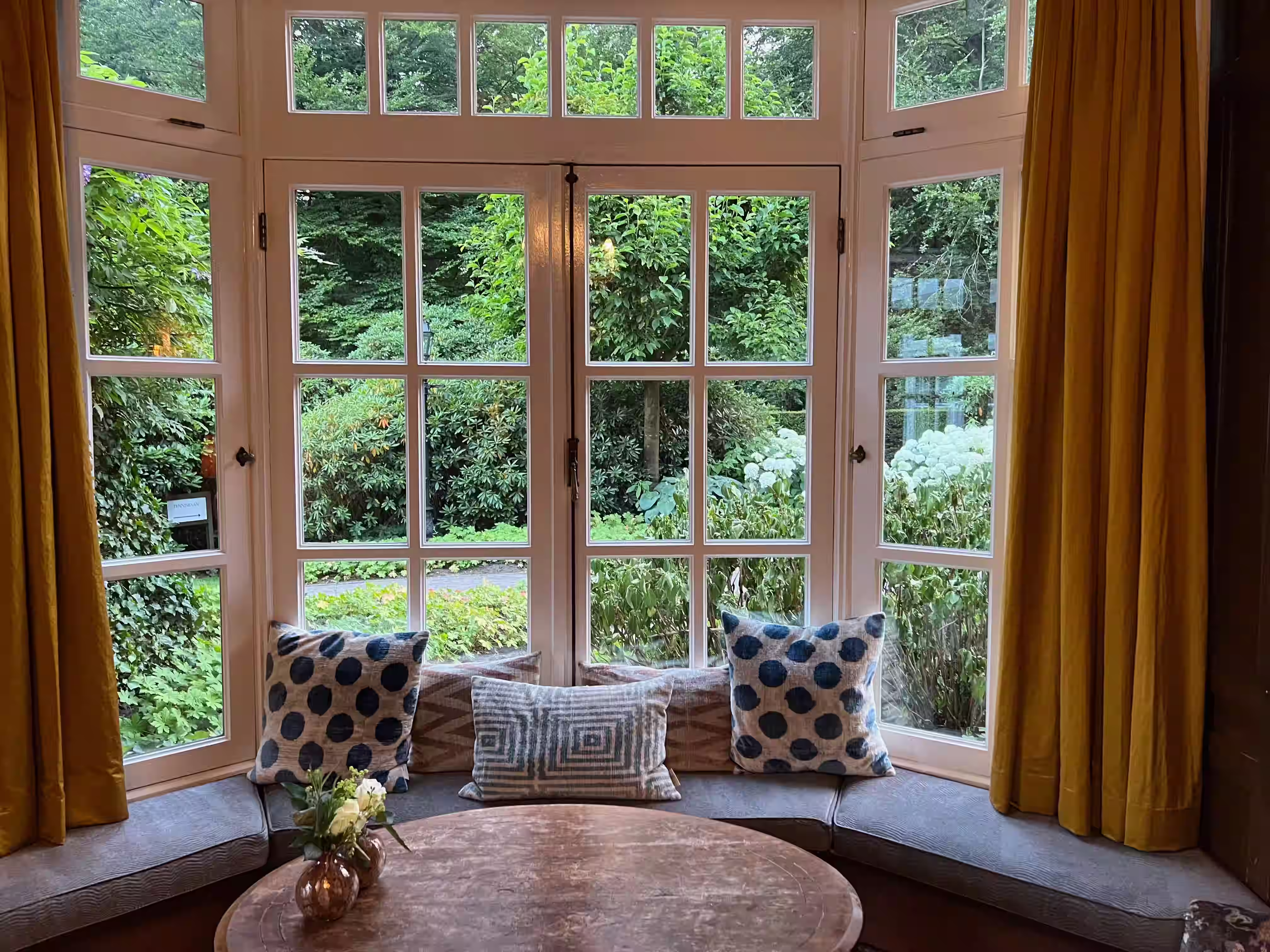 Newly built conservatory with large glass panels and dark roof, showcasing ongoing interior work with visible construction materials.
