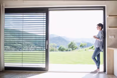 Spacious white room featuring a sleek sliding aluminium door, highlighting contemporary style and elegance.