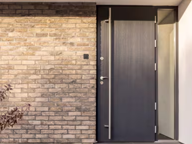 Brick wall featuring a door and window, showcasing a stylish heritage aluminium door for modern UK homes.