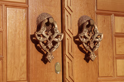 Close-up of a gold-plated door knocker, showcasing modern design for composite doors in the UK.