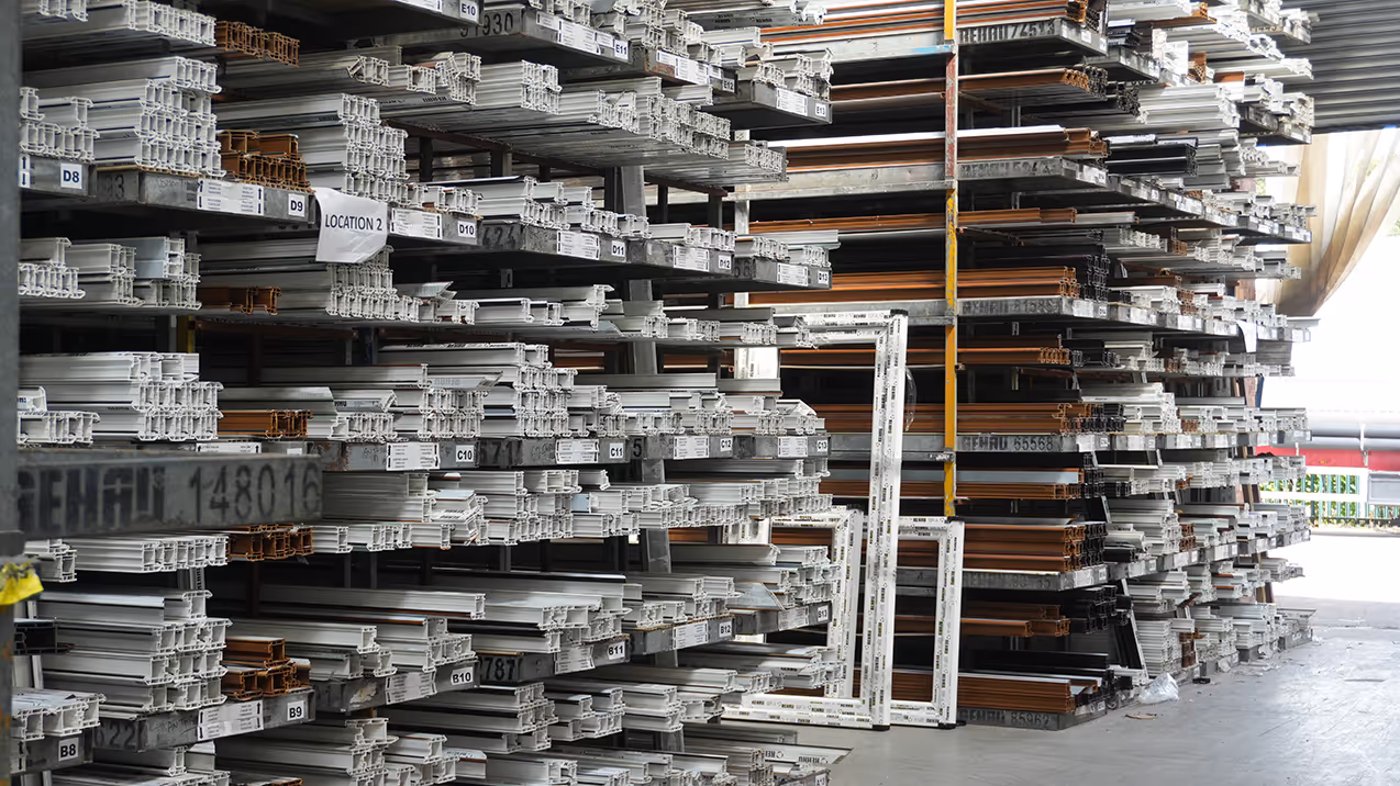 A spacious warehouse filled with various types of metal materials stacked on shelves and pallets.