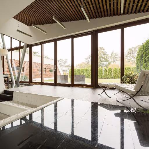 Contemporary house with expansive sliding glass doors leading to a furnished patio