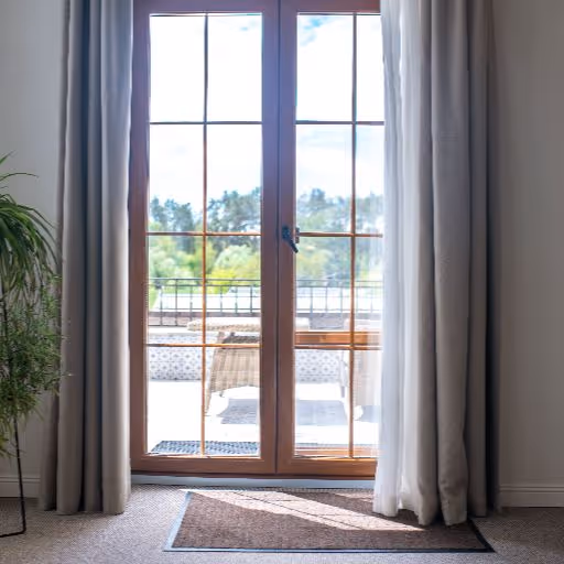 Interior view through large sliding glass doors framed by blue curtains