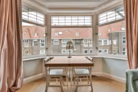 Bay window with table and chairs creating a cozy dining space