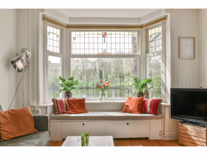 Tall four-pane window overlooking a lush garden