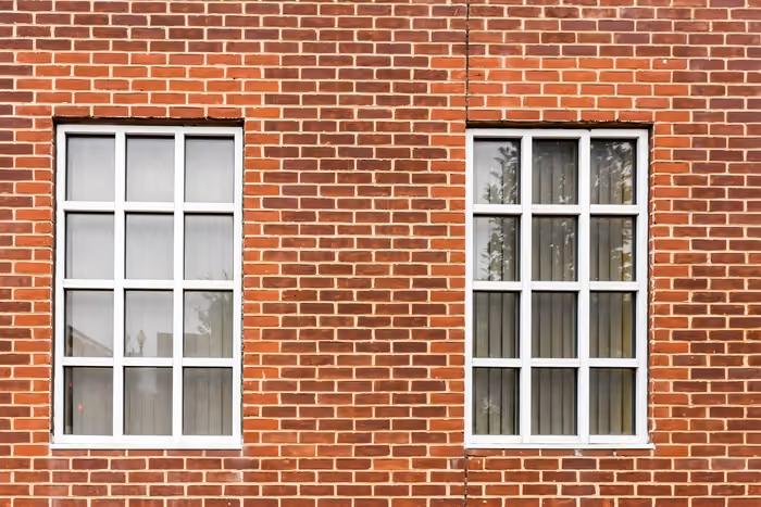 Tall four-pane window overlooking a lush garden