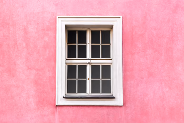 Tall four-pane window overlooking a lush garden