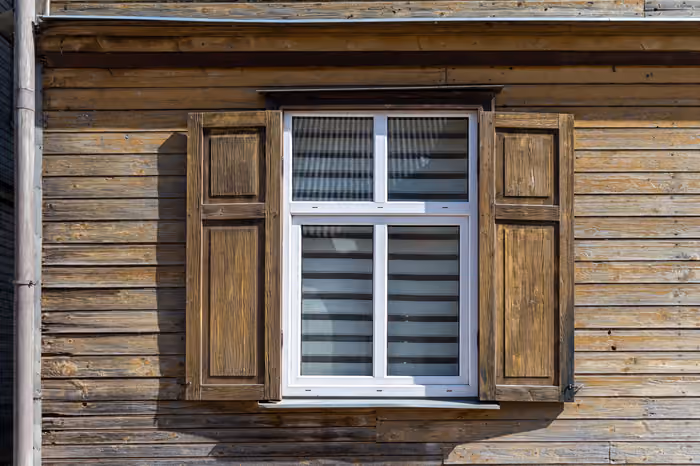 Tall four-pane window overlooking a lush garden