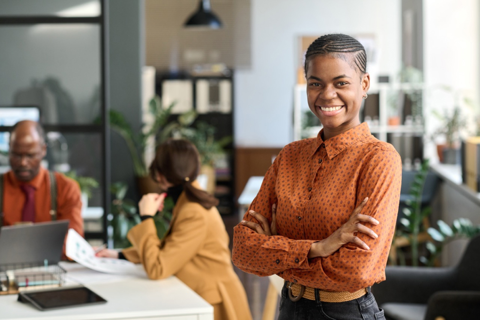 A smiling woman in an office hired through the Wamly all-in-one hiring solution.