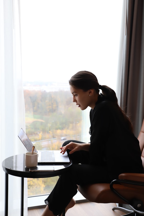 a woman sitting in a chair using a laptop computer