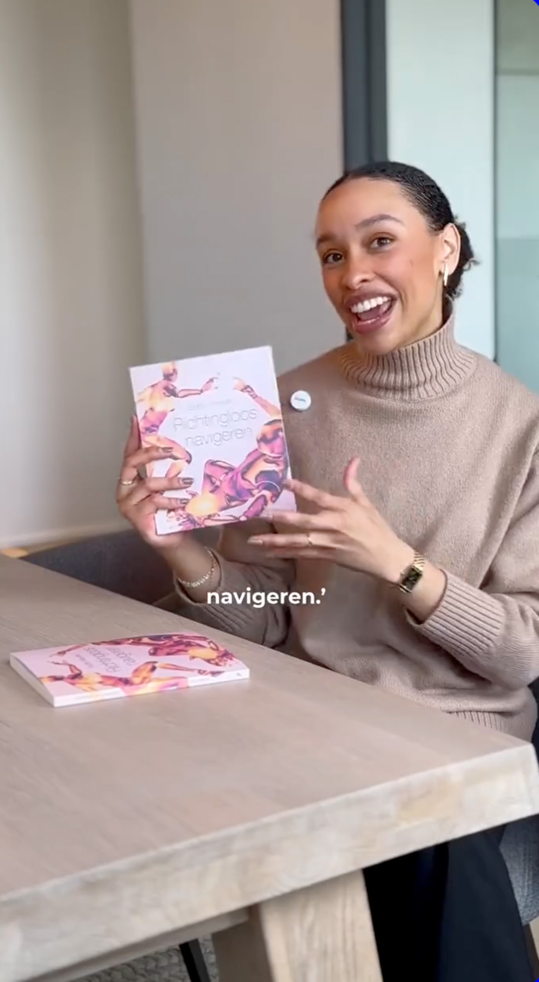 Een vrouw toont een boek aan de camera. Ze geeft er uitleg over.
