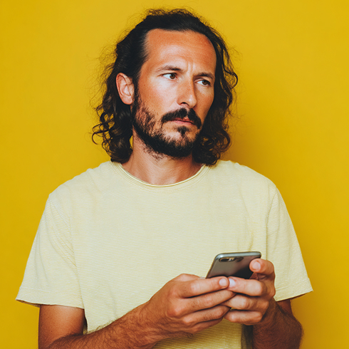 Een man met korte baard met smartphone
