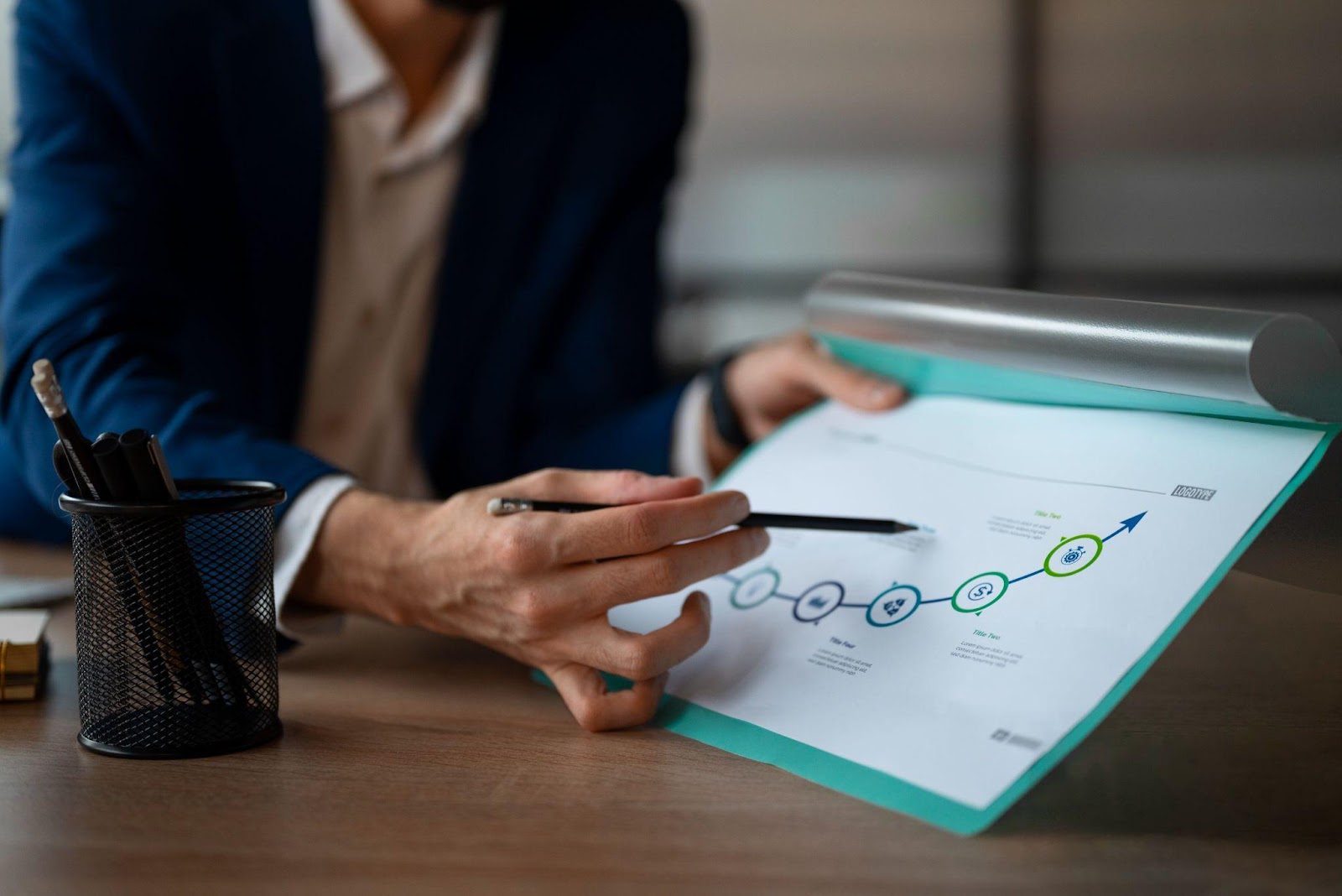 Person reviewing a business growth chart during a planning meeting.