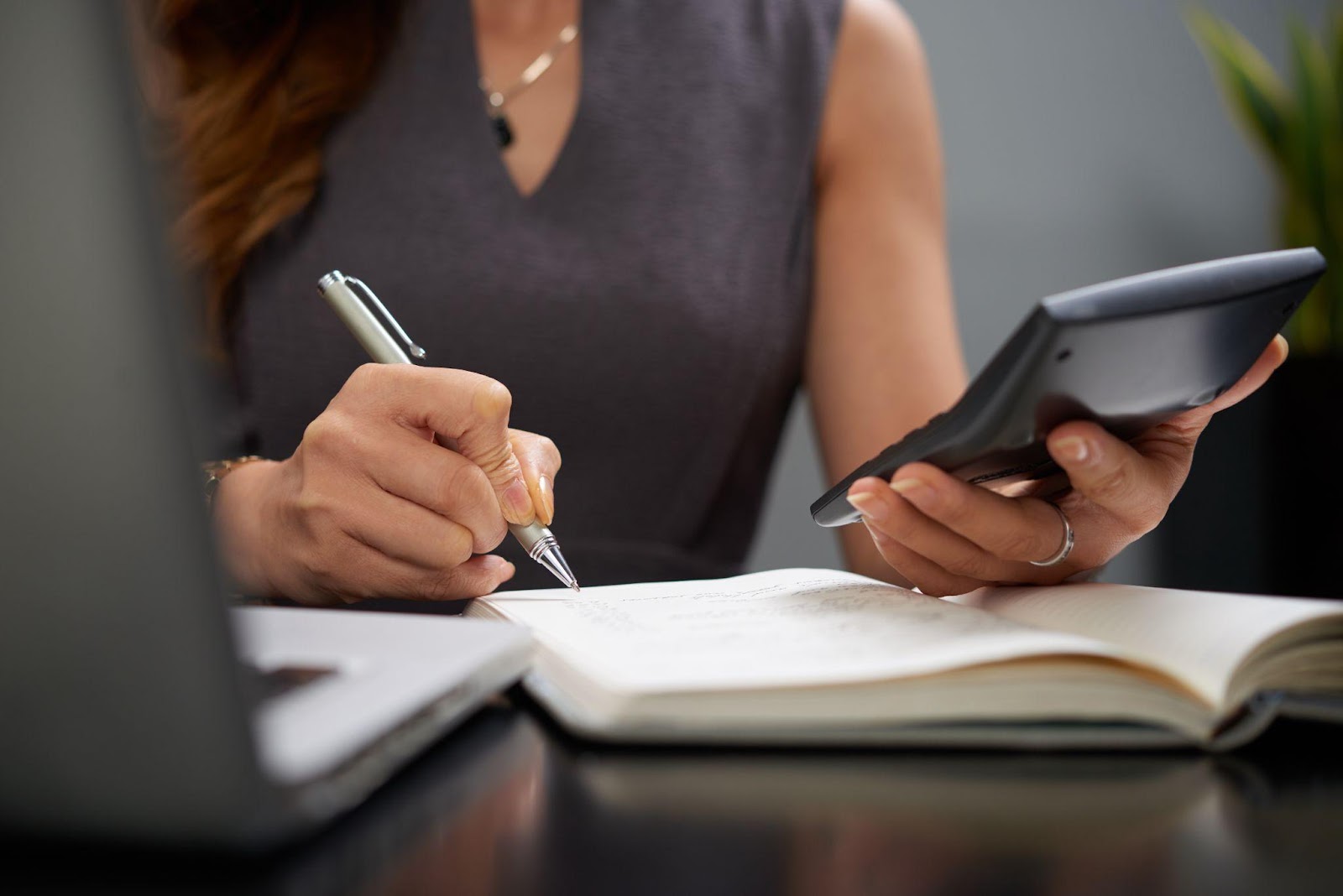 business woman taking notes and using a calculator