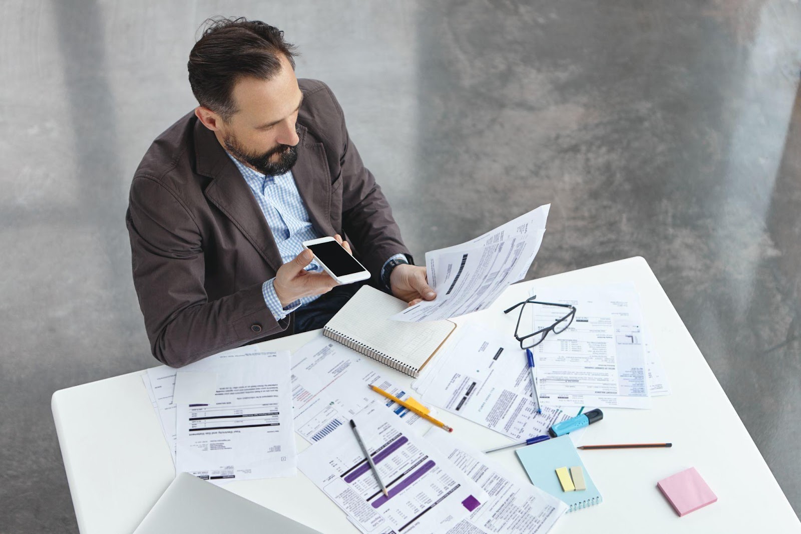 A man working with his phone and business papers.