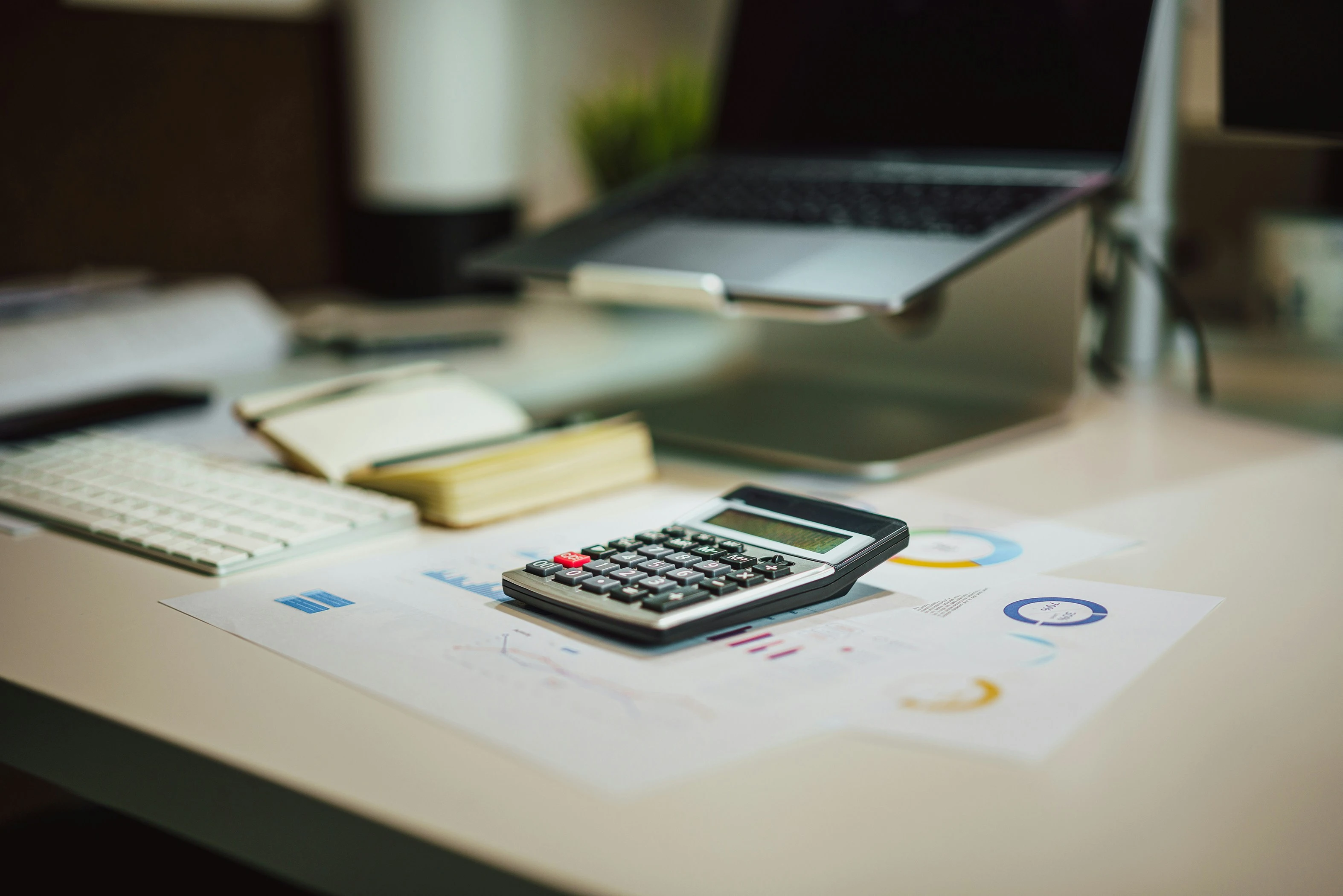 A calculator placed on a wooden desk with tax documents