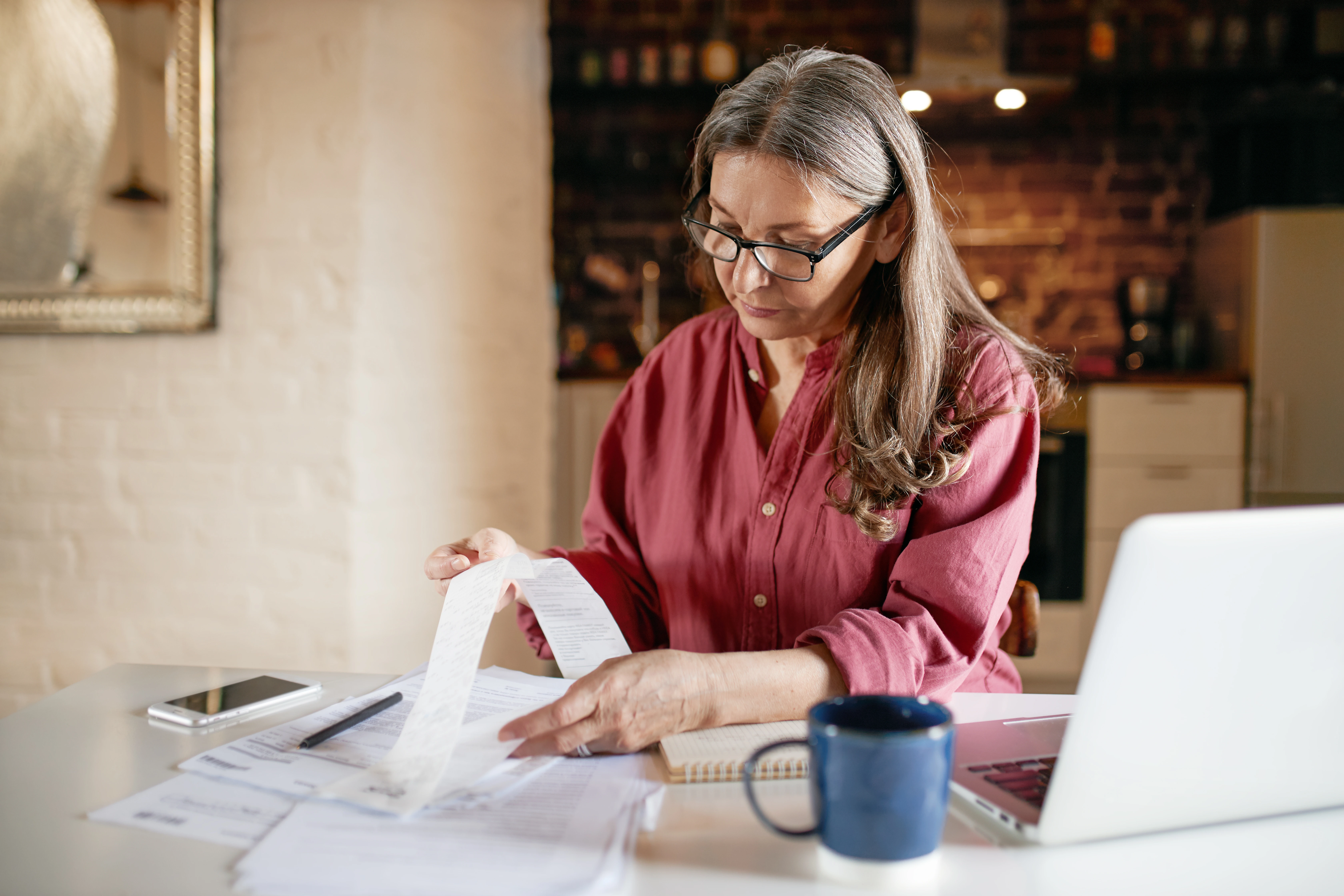 Businesswoman manual invoicing next to her desktop