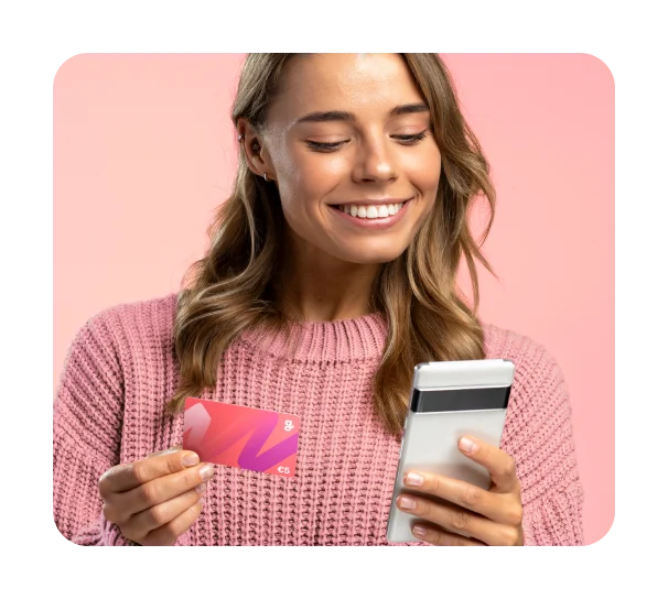 Woman in a pink sweater holding Giftify card and her phone