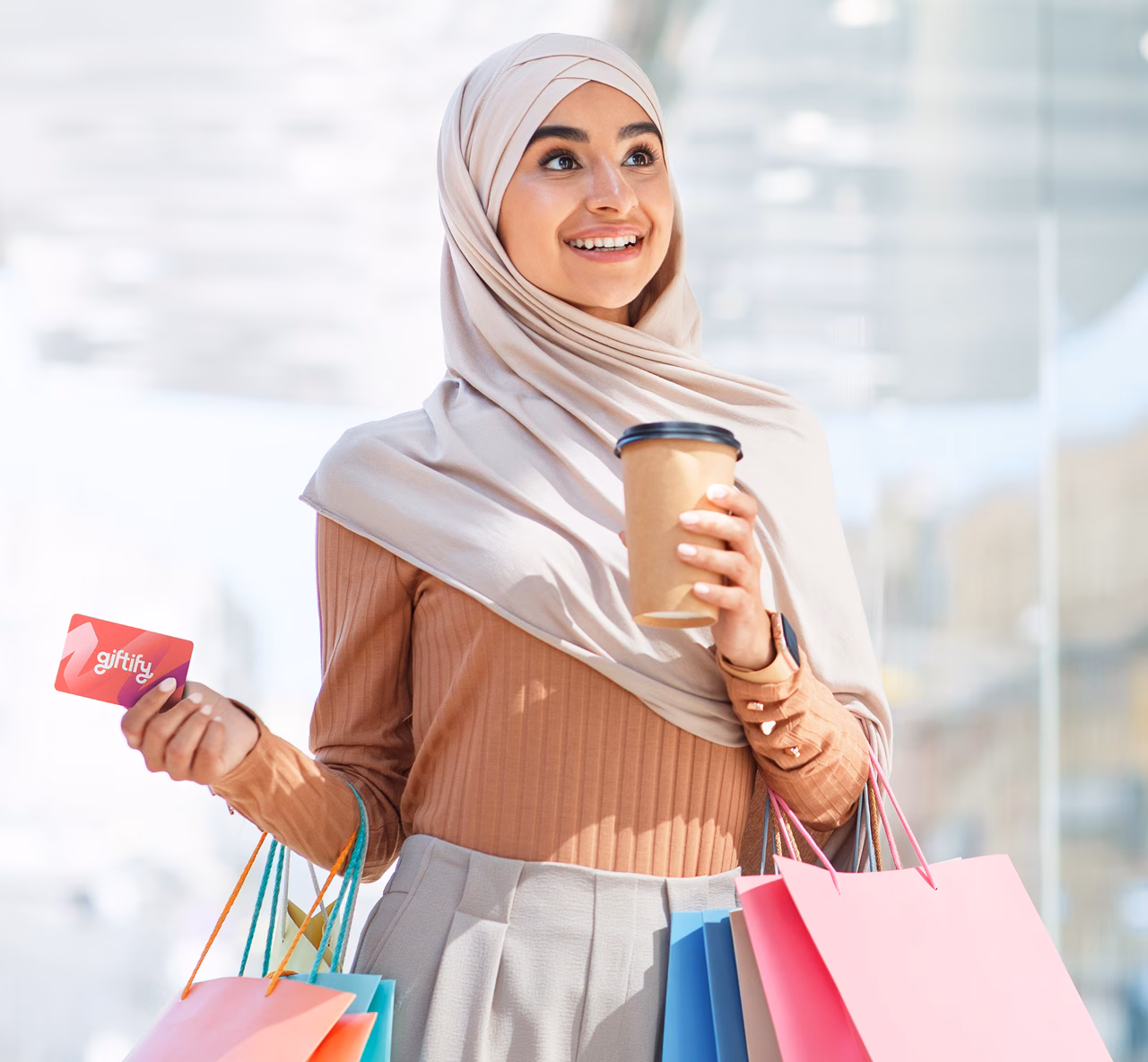 Woman holding a cup of coffee and a Giftify Card