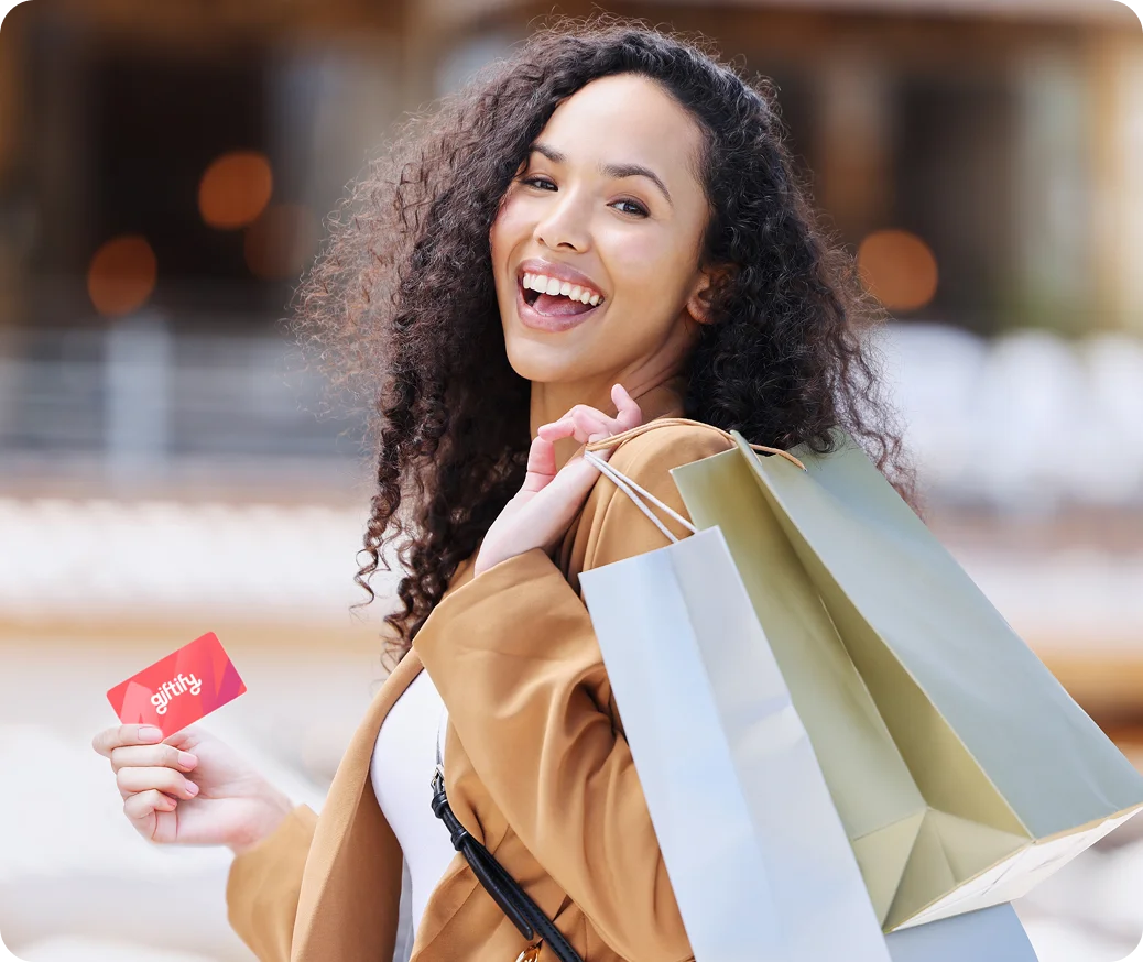 Curly haired woman holding gift card 