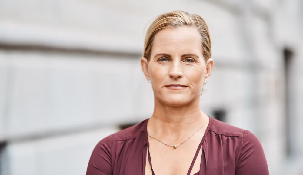 Porträt einer Kundin von MK Concepts vor einem Gebäude, seriös und professionell