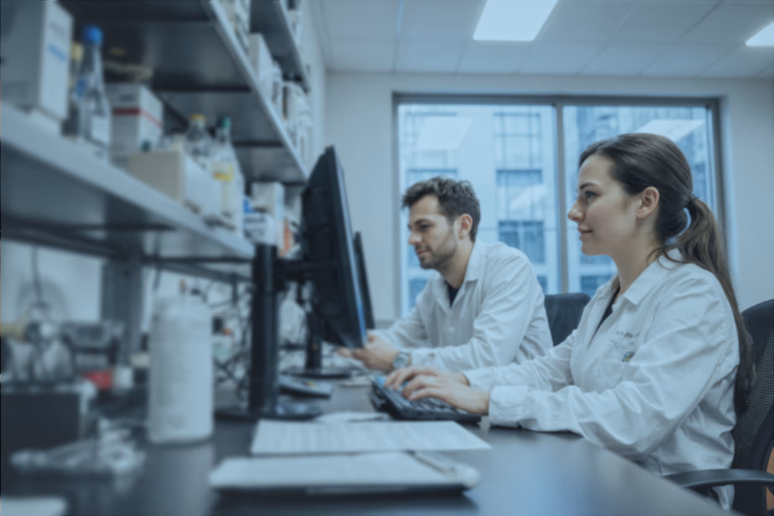 2 biologists working and smiling on computer