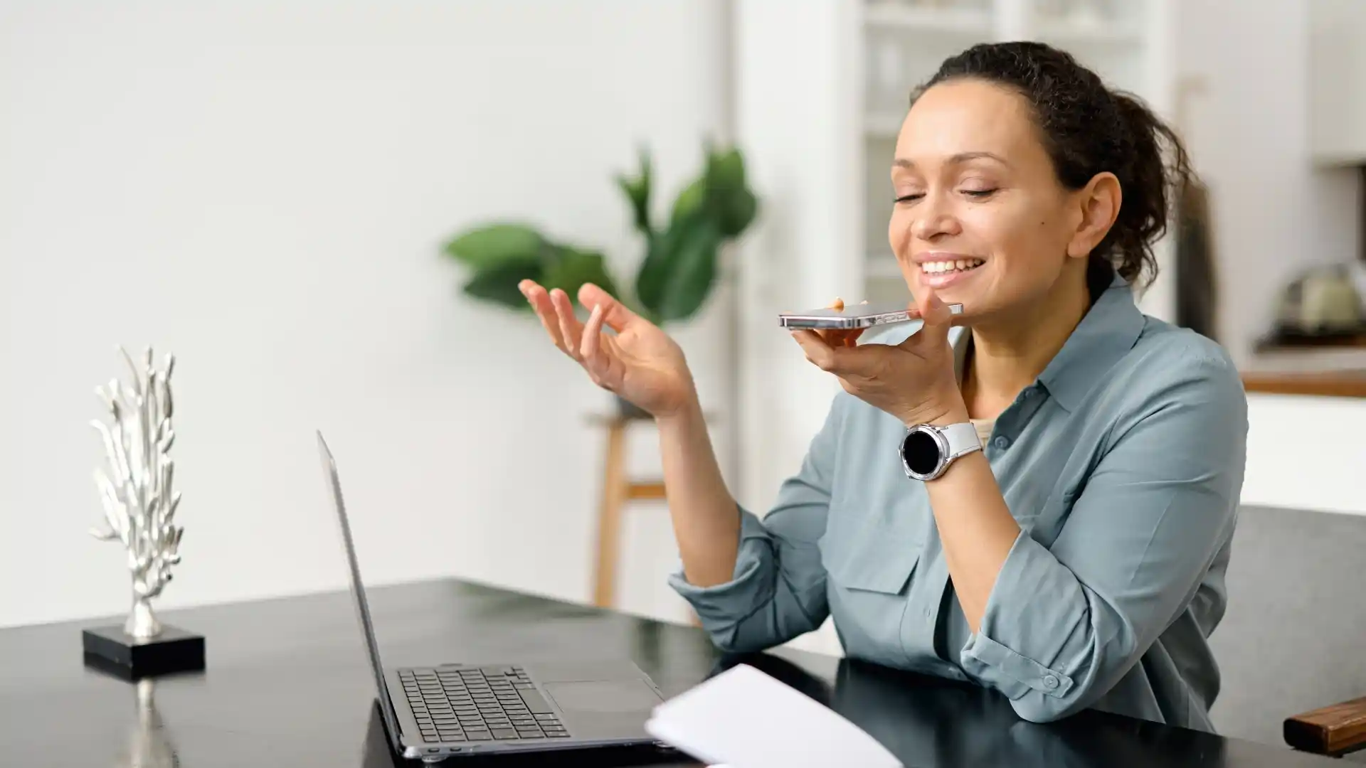 A female customer smiling as she speaks on the telephone with a voice assistant.