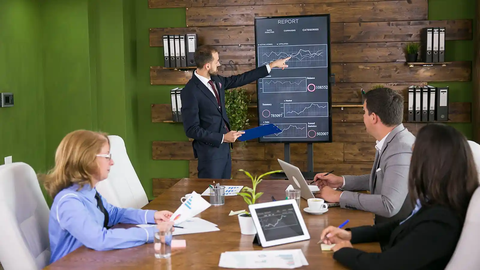 Sharp manager presenting business results chart to a board of directors.