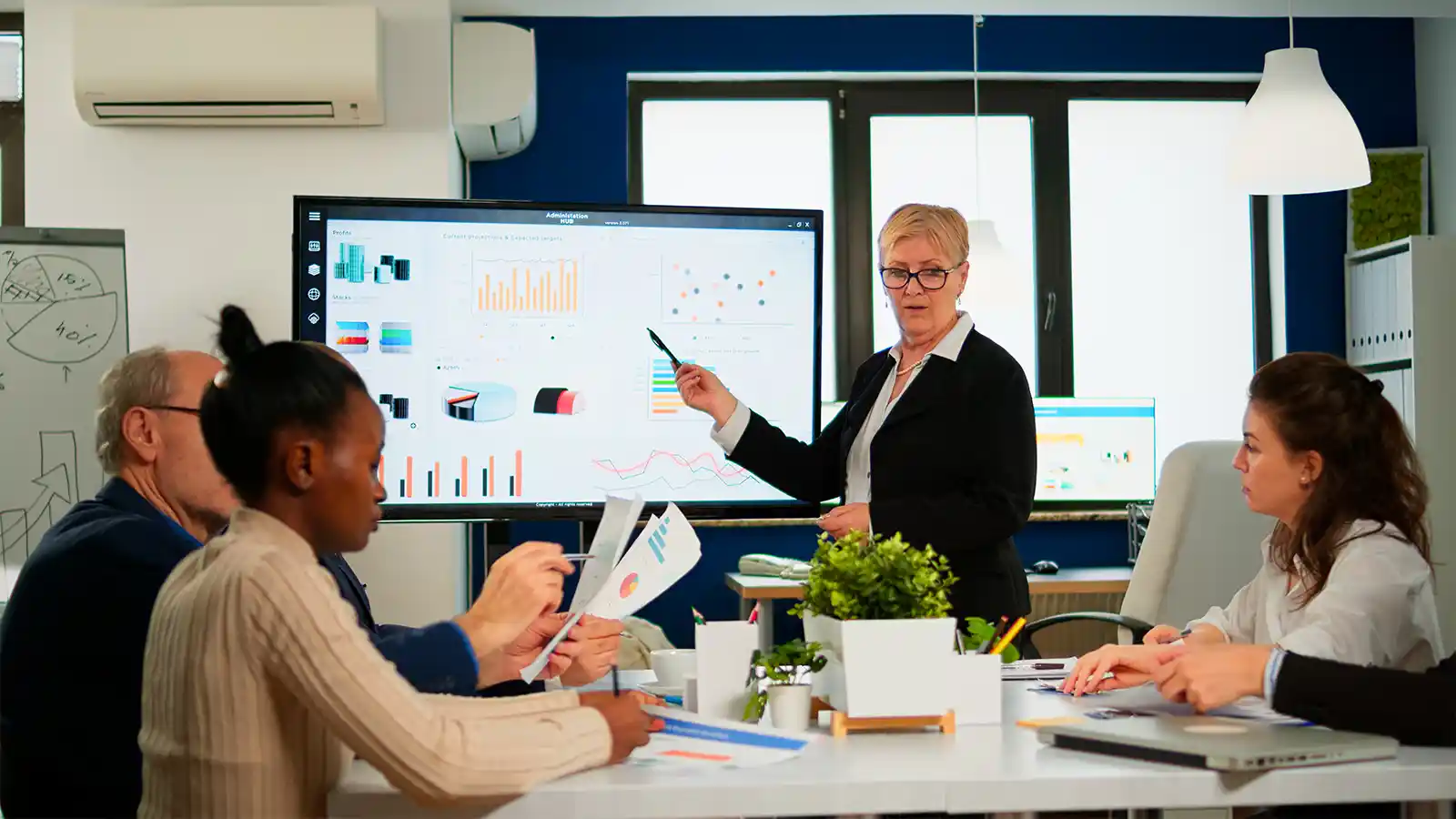Manager using a display to present key features to the team.