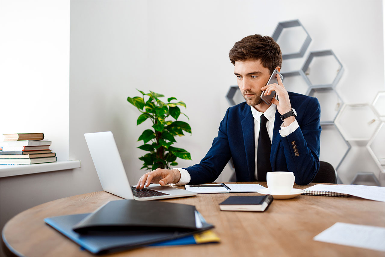 A man in headphones is at a desk, engaged with his computer, creating a focused work environment.