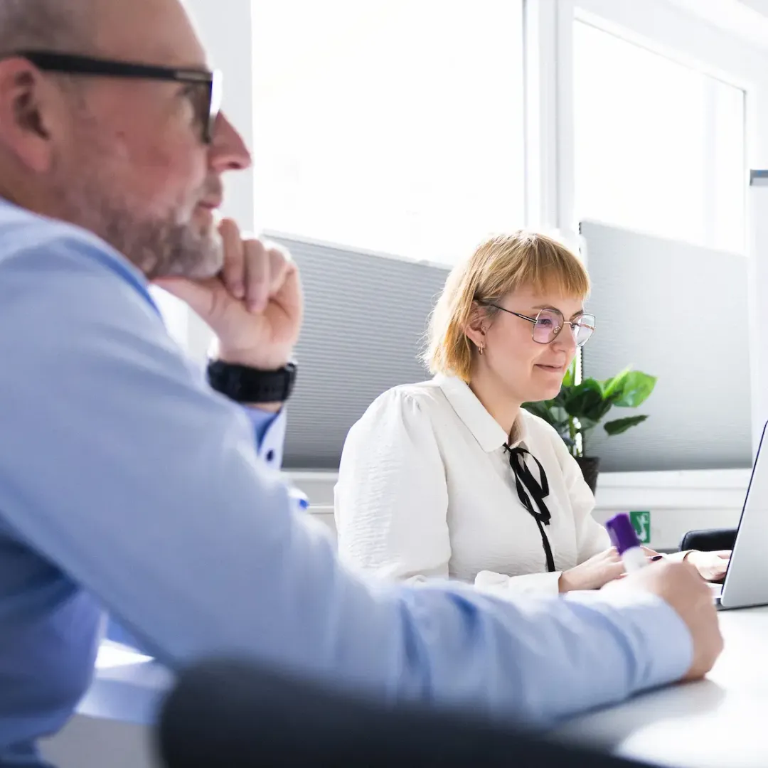 Zwei Personen sitzen in einem Meeting