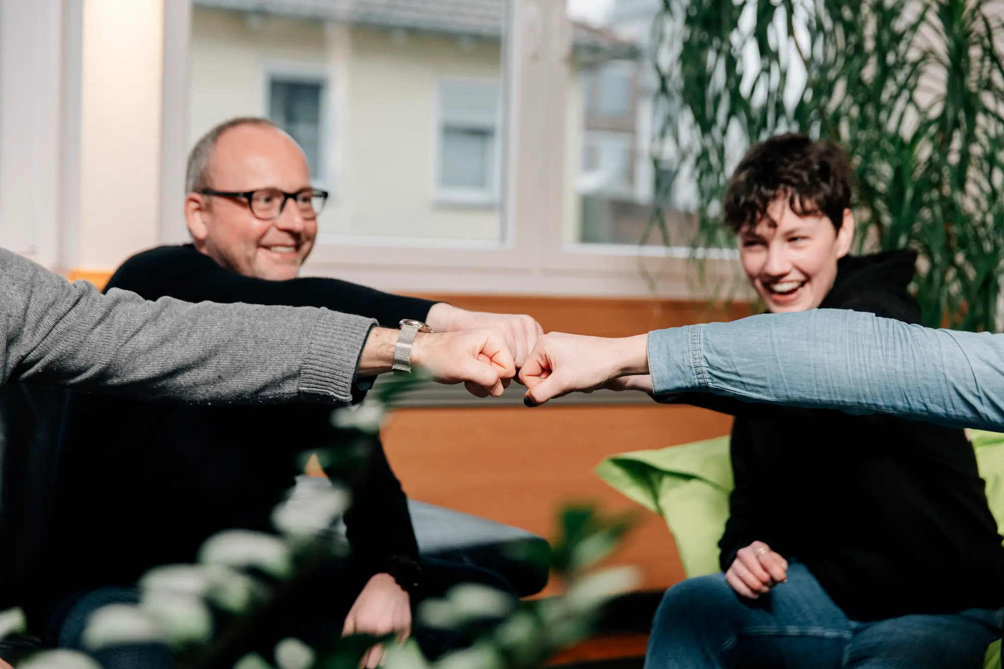 Mehrere Personen strecken freundschaftlich die Fäuste zusammen.