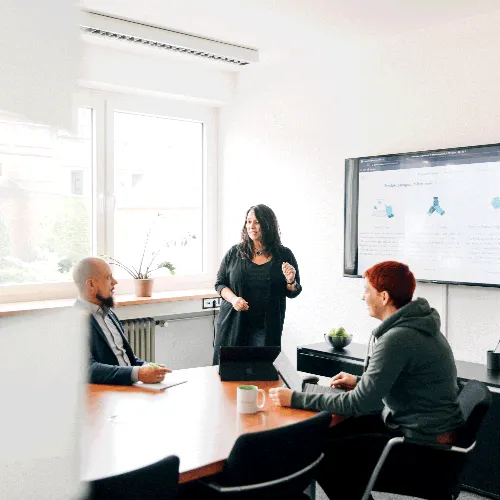 Mehrere Personen halten ein Meeting in einem Besprechungsraum.