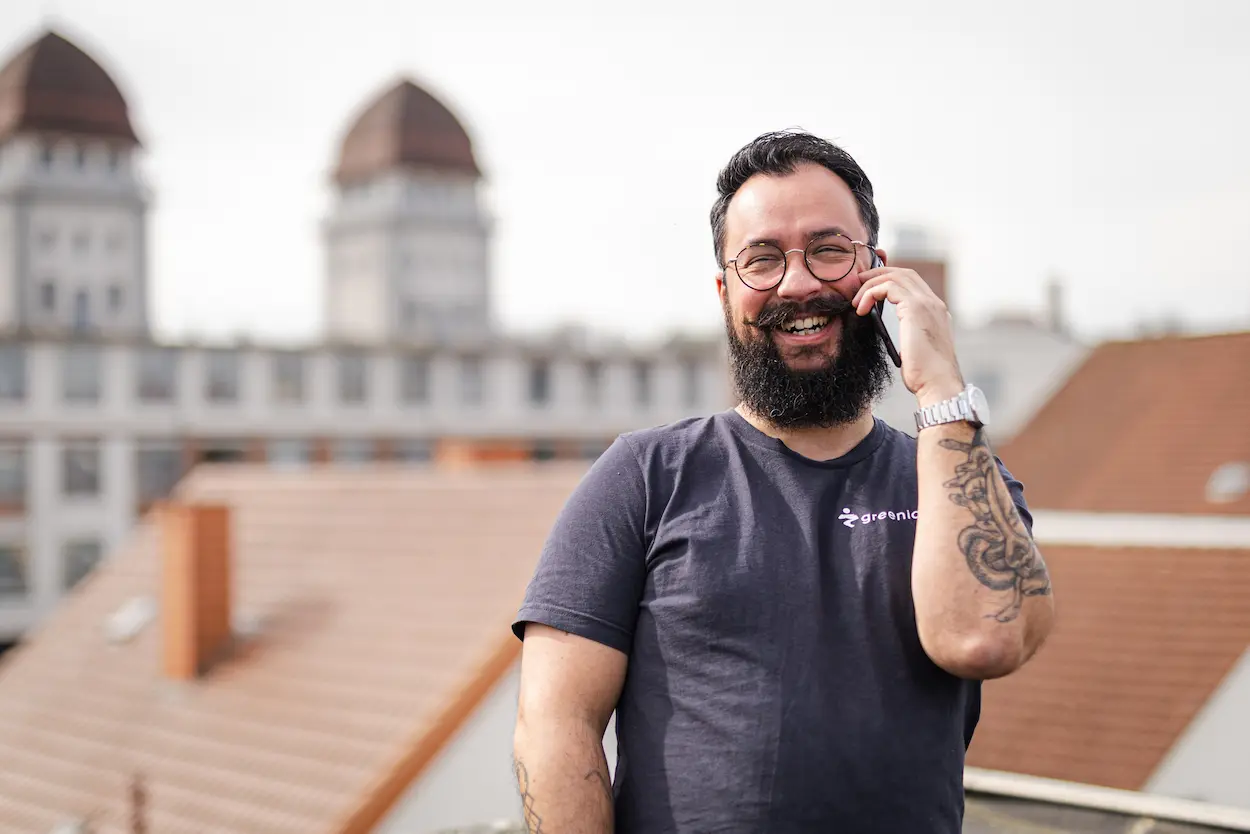 Mann telefoniert vor Häuserdach-Panorama.