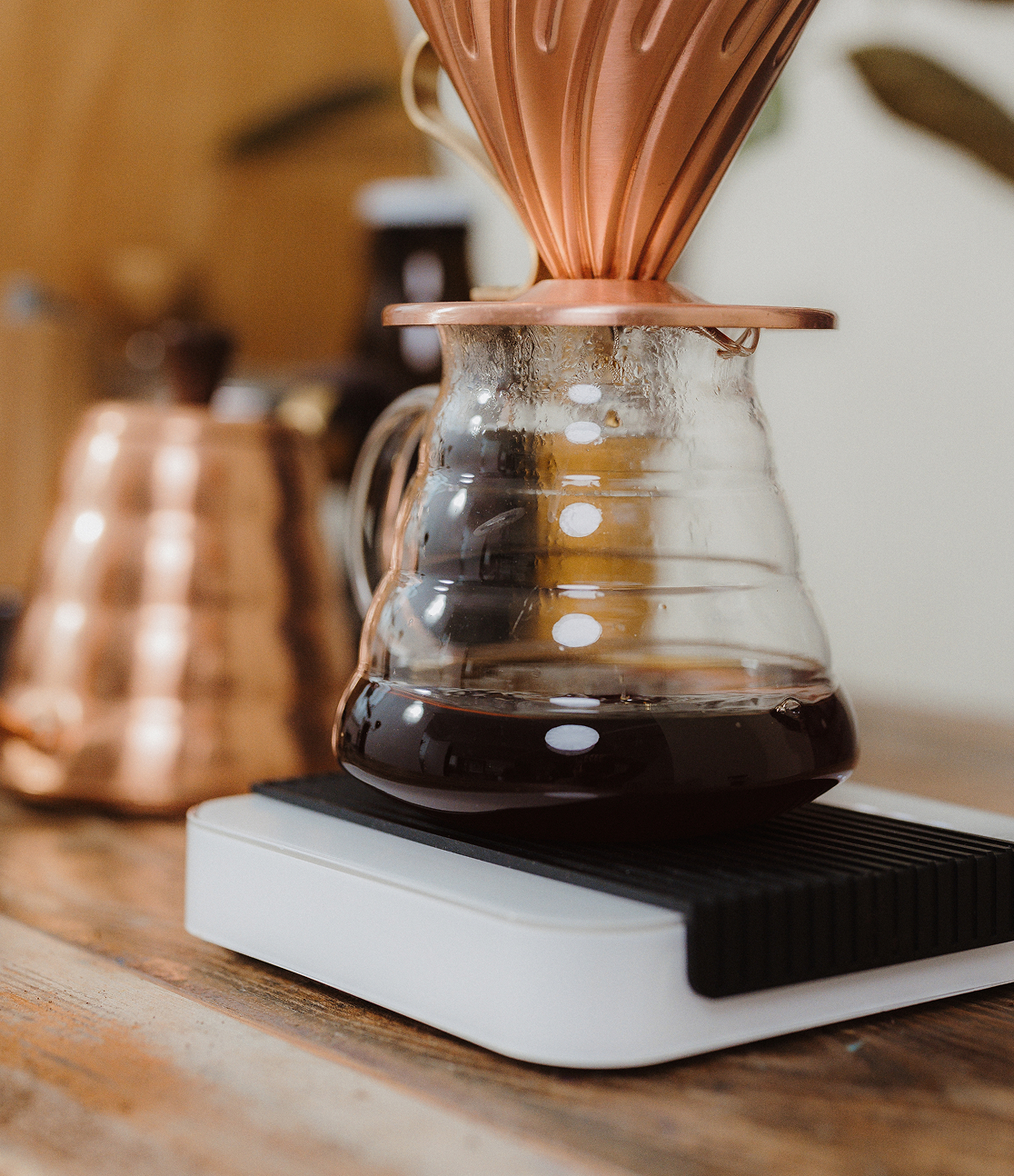 Glaskaraffe mit frisch gebrühtem Kaffee steht auf einer digitalen Waage.