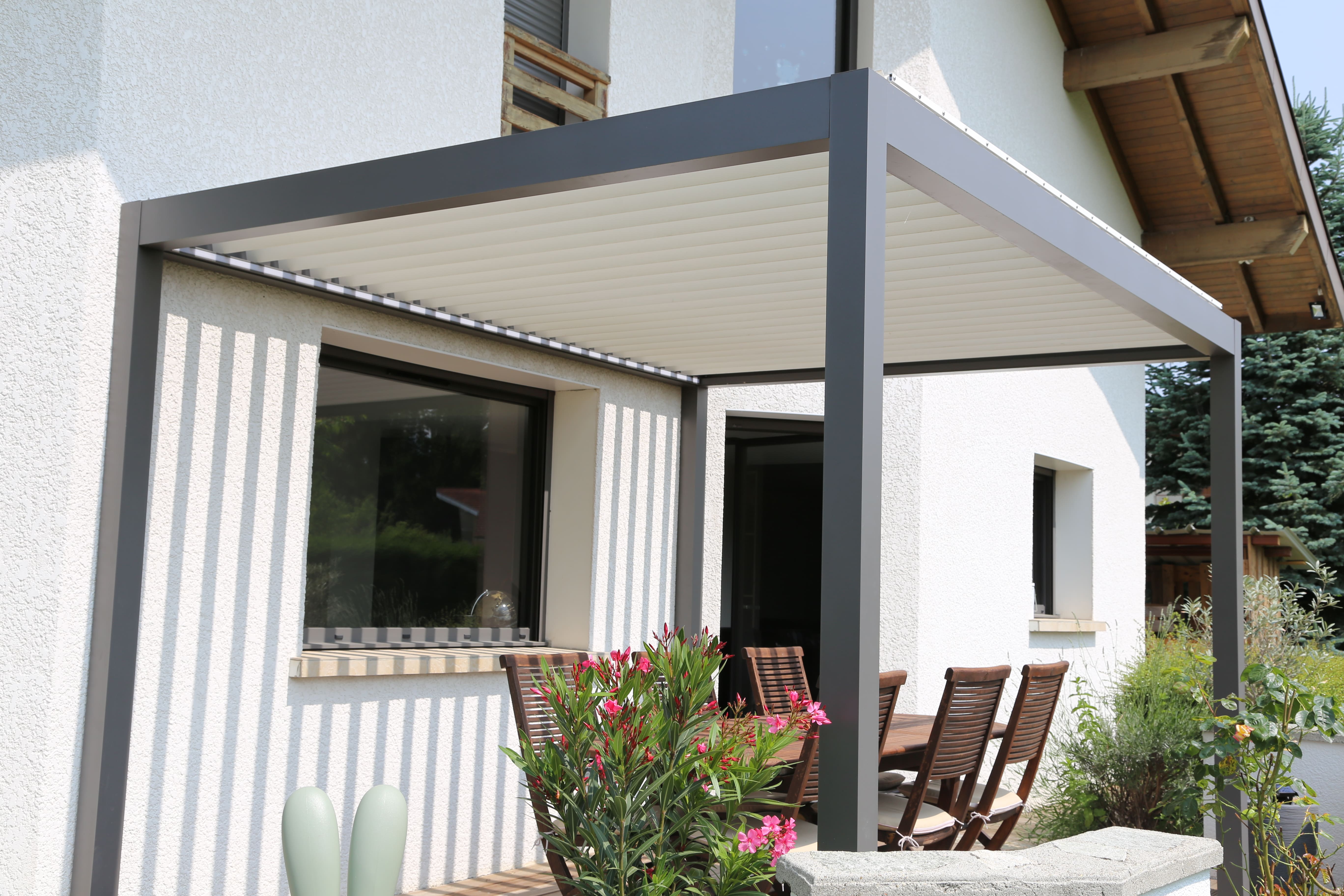 Pergola bioclimatique à lames orientables et rétractables installée sur une terrasse à Annecy