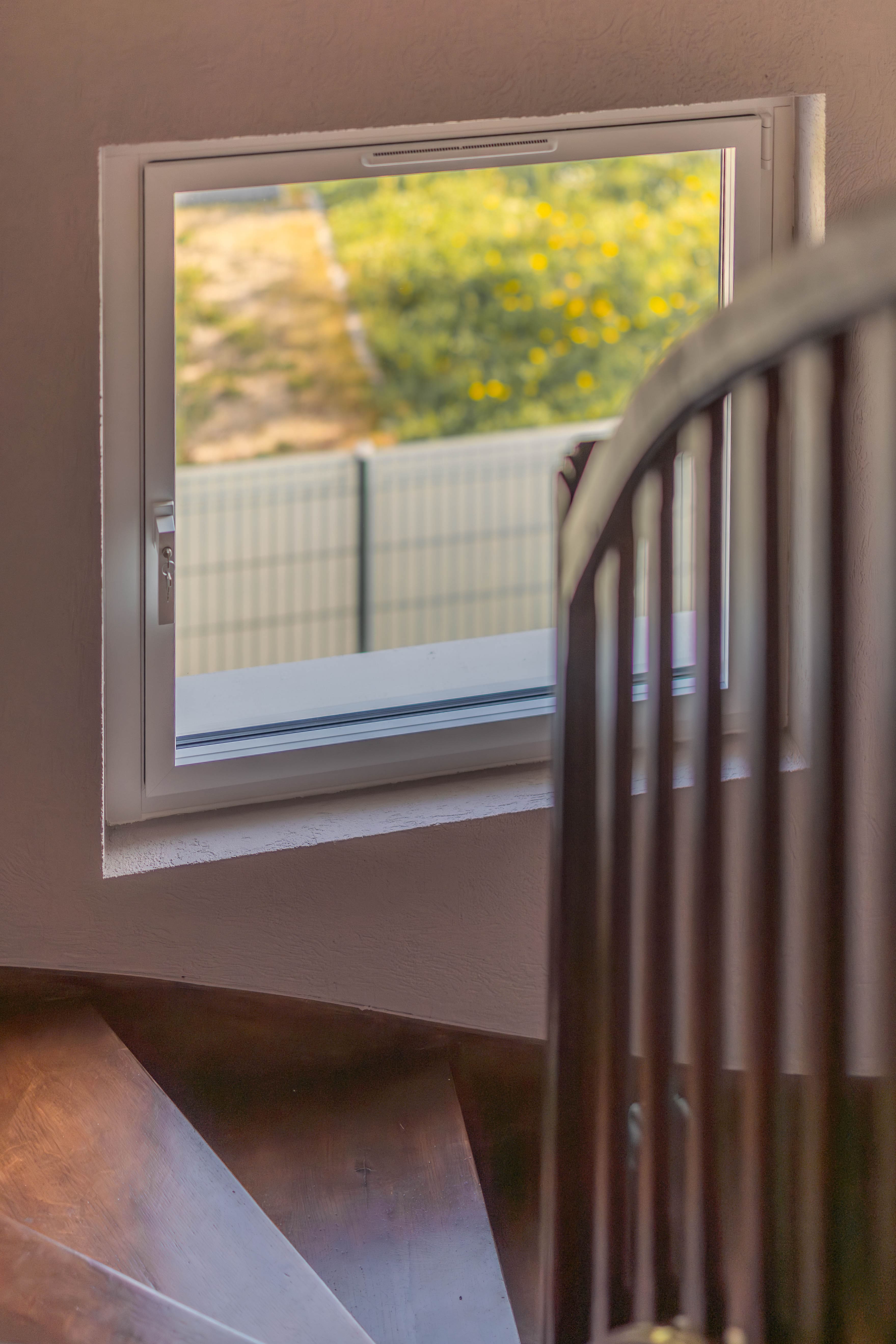 Fenêtre rénovée dans une cage d’escalier avec finition soignée