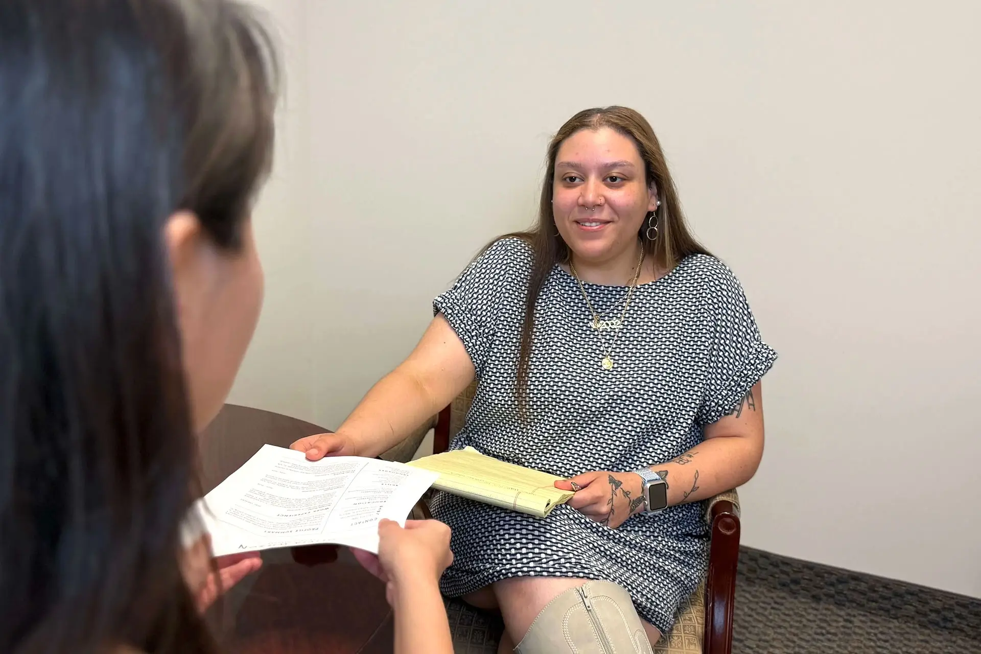 The candidate delivers her resume to the recruiter