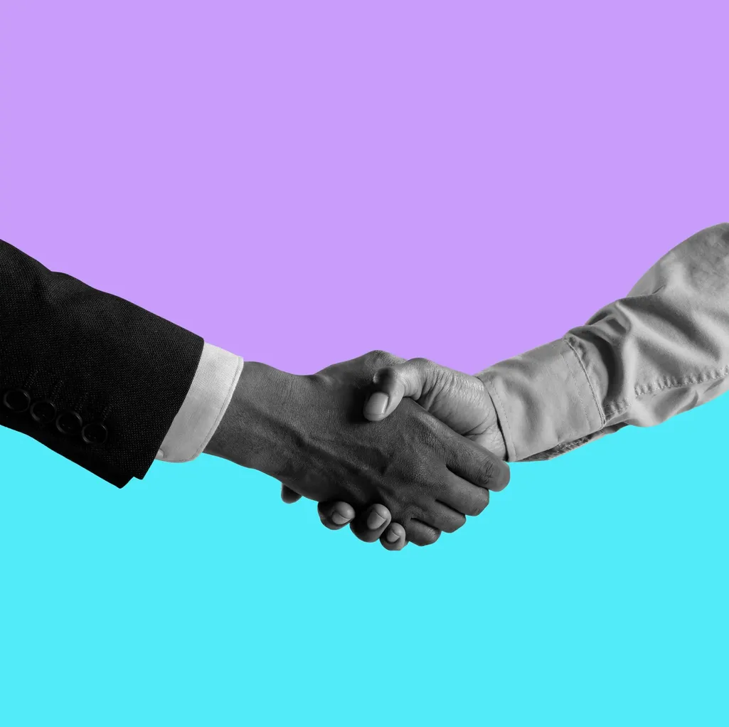 A grayscale image depicts two hands shaking hands against a backdrop of vibrant, contrasting colors