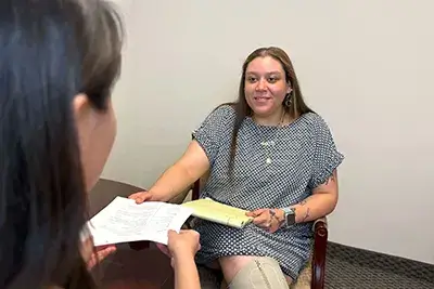 The candidate delivers her resume to the recruiter.
