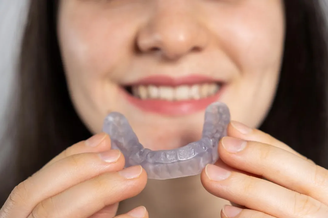 woman wearing a night guard for treating TMJ