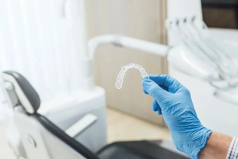 dentist holding an Invisalign clear aligner