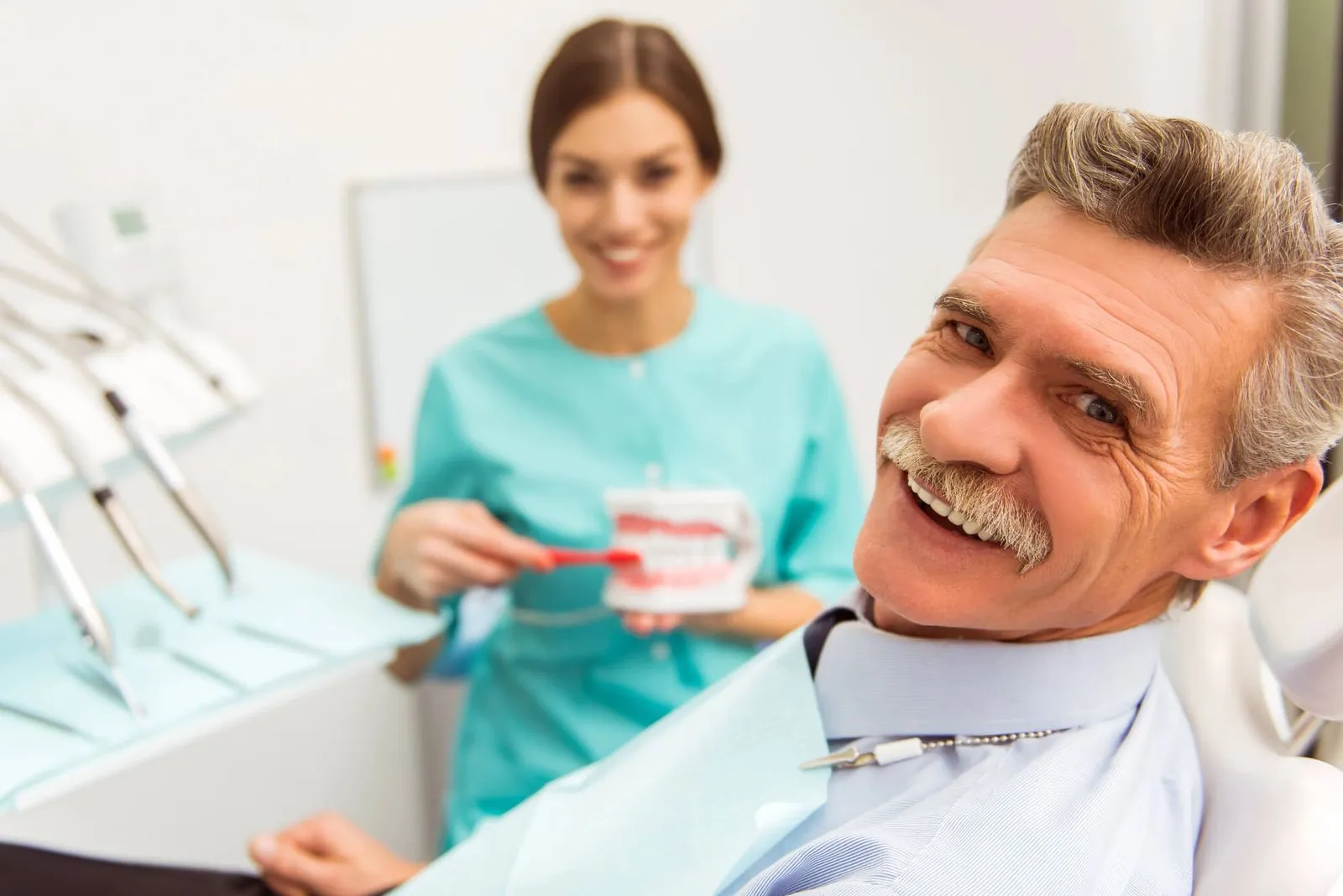 older man sitting in the dental chair and smiling