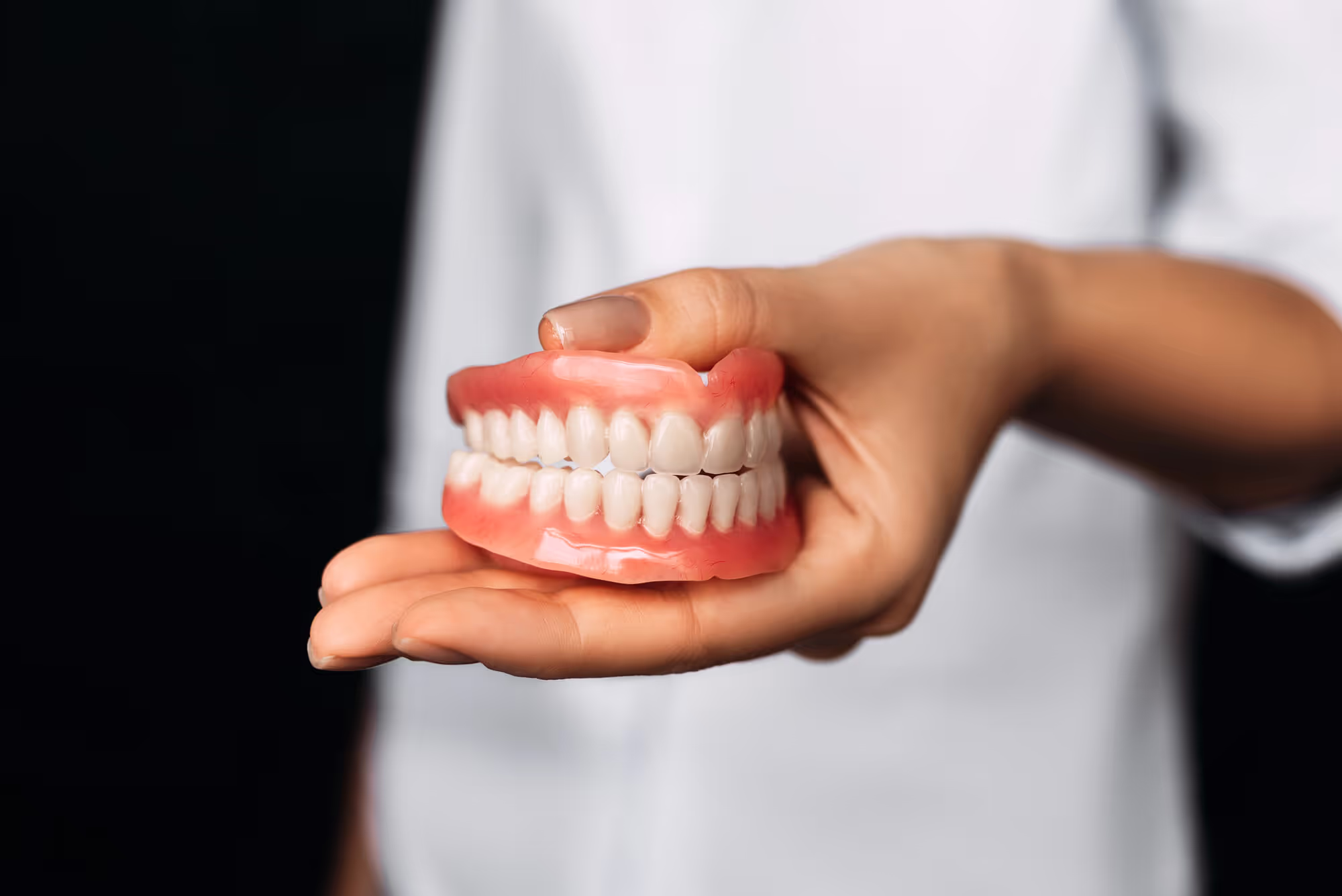 a dentist holding a set of removable dentures
