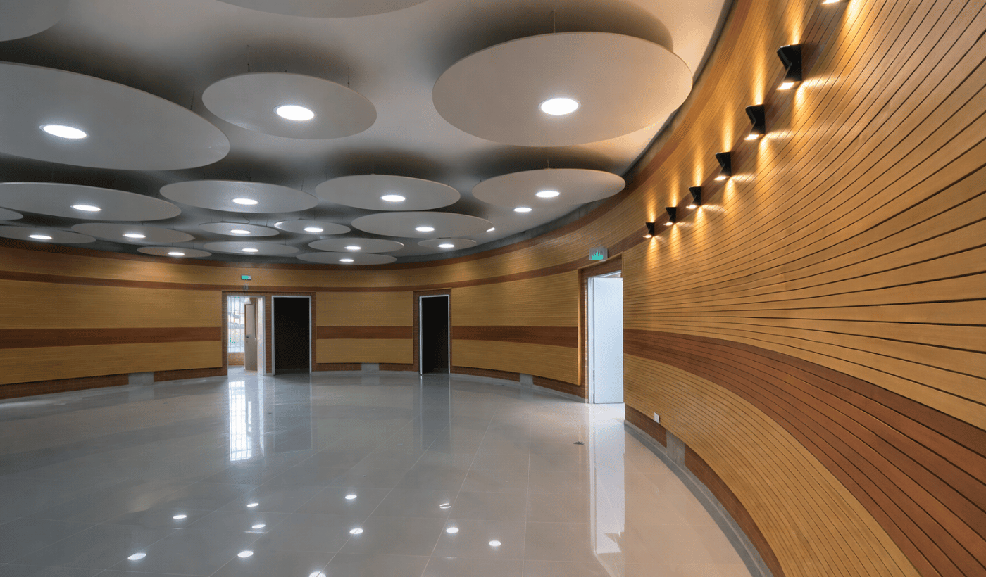 Sala circular vacía con paredes de madera y techo con luces circulares empotradas.