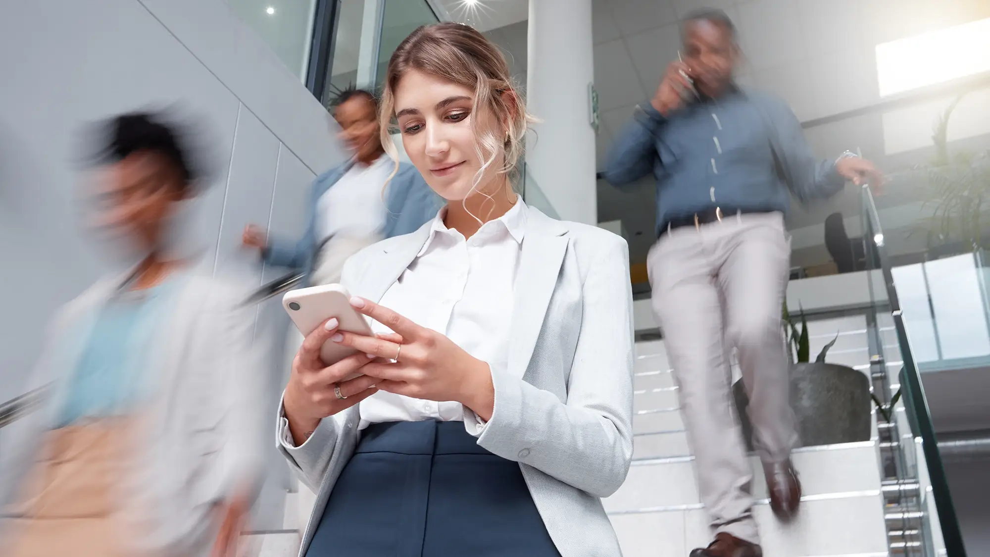 Candidate engaging with a fast recruitment process on a mobile device as others move quickly by, illustrating that speed wins in today's job market.