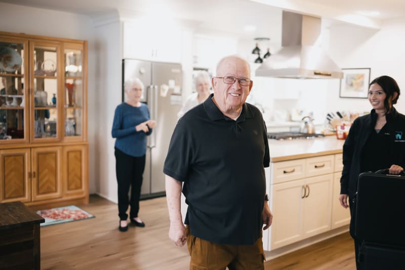 Dental professional assisting senior patient with teeth brushing technique at home