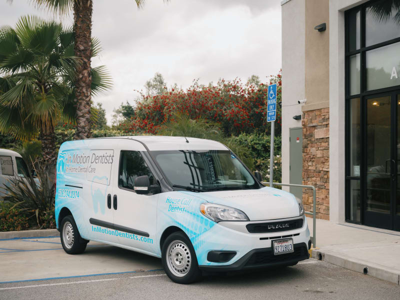 Mobile dental van with company branding parked outside residential home