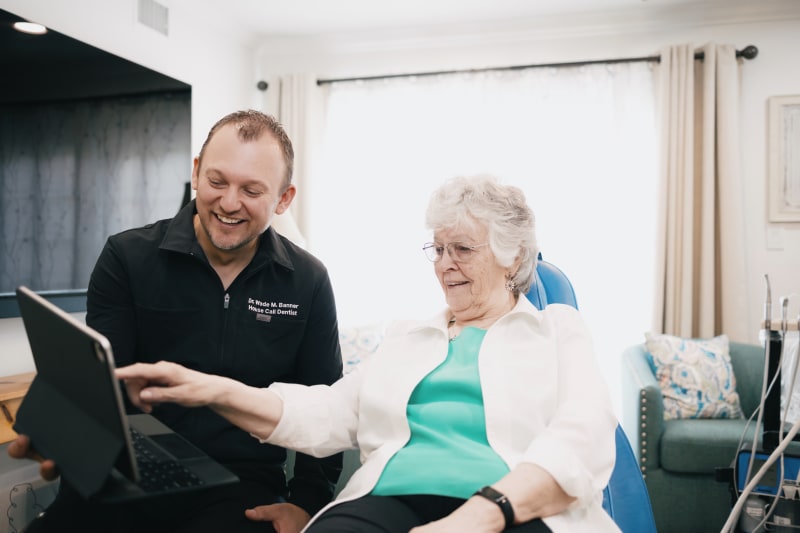 Dentist performing examination or cleaning on senior patient at home