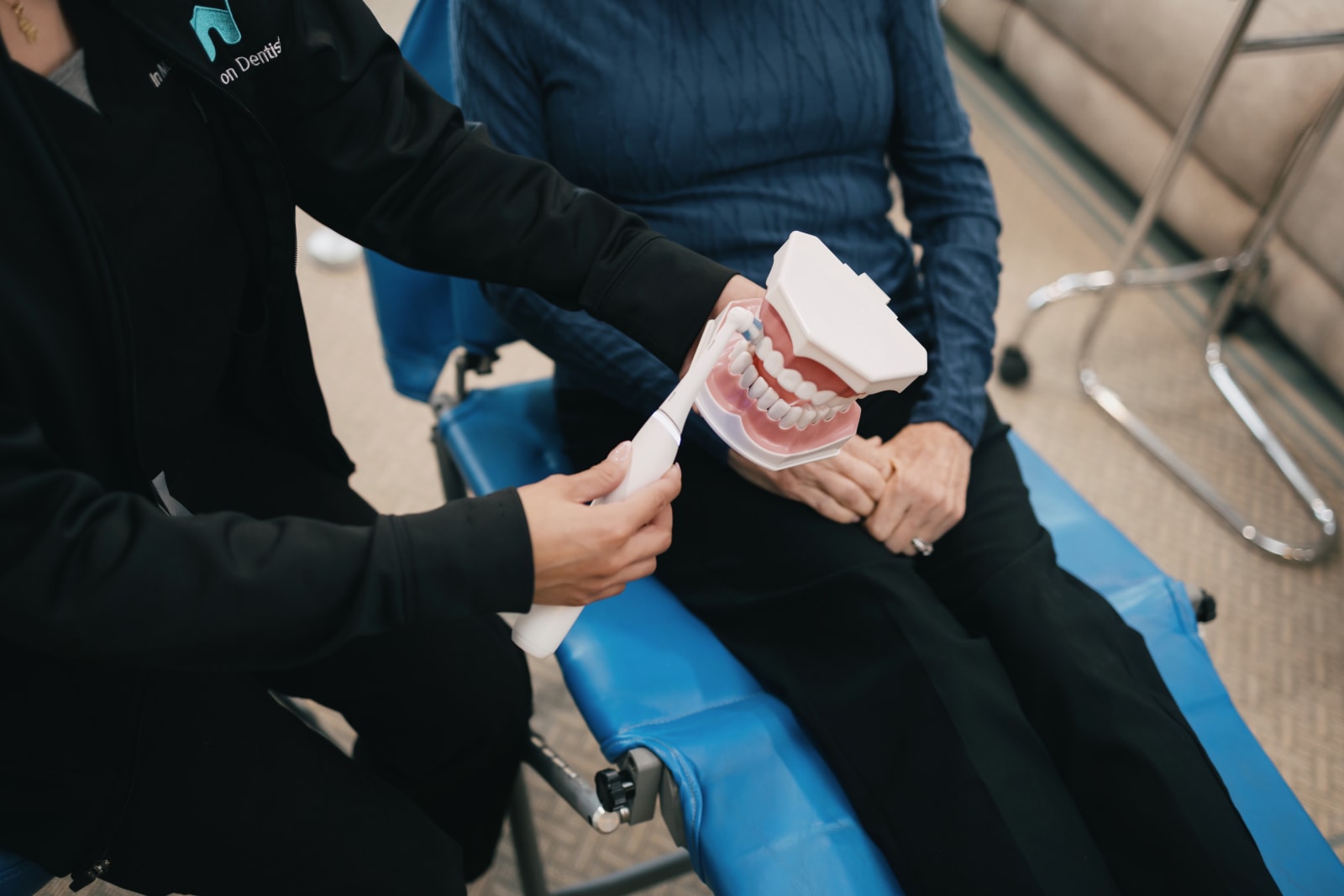 Dental professional holding dental model with patient during in-home consultation